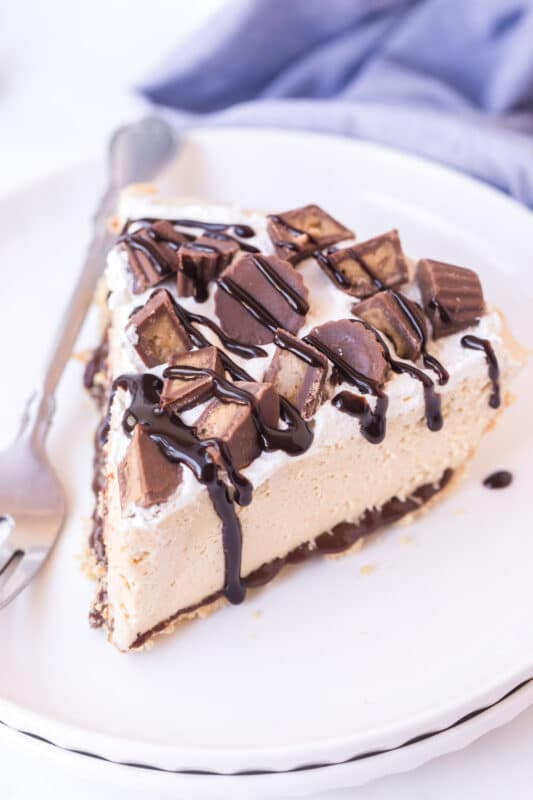 Slice of peanut butter pie on two plates with a blue napkin