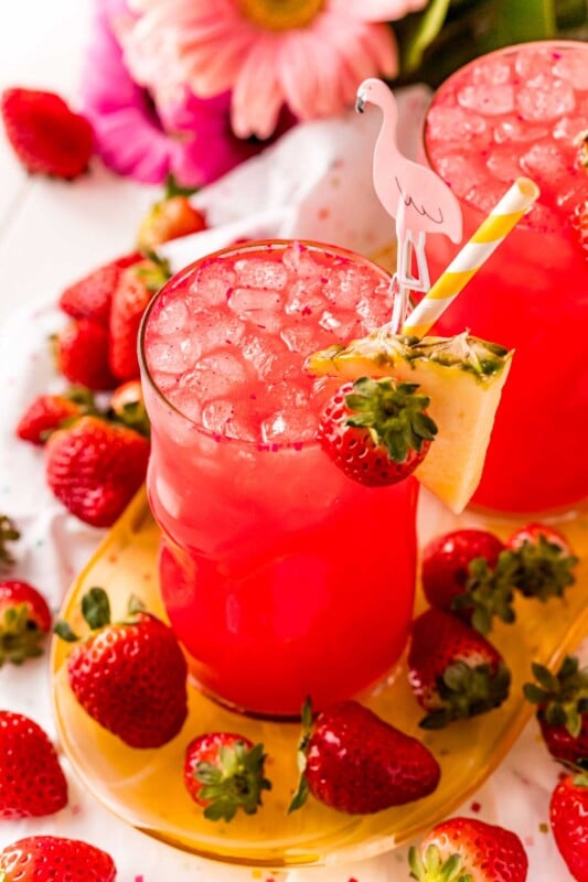 Red cotton candy drink with ice and a pineapple wedge garnish