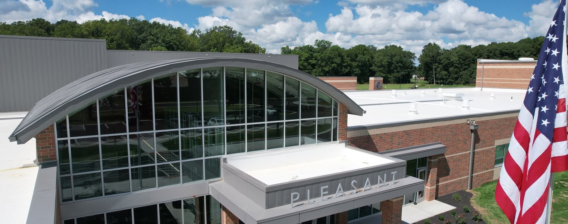 front of new building, american flag on right