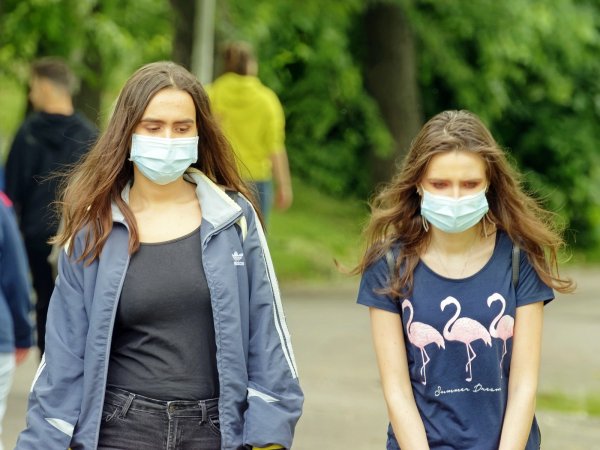 two women wearing masks outside