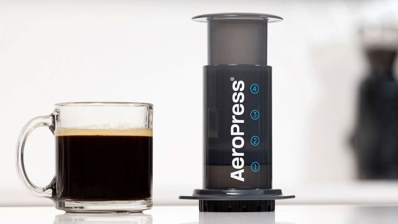 Aeropress with a cup of coffee sitting on a table