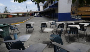 Student desks sit in the shade next to the parking lot of the closed Francisco Beckman high school, where a professor who died of the coronavirus worked, on the outskirts of Panama City, Panama. (AP Photo/Arnulfo Franco)