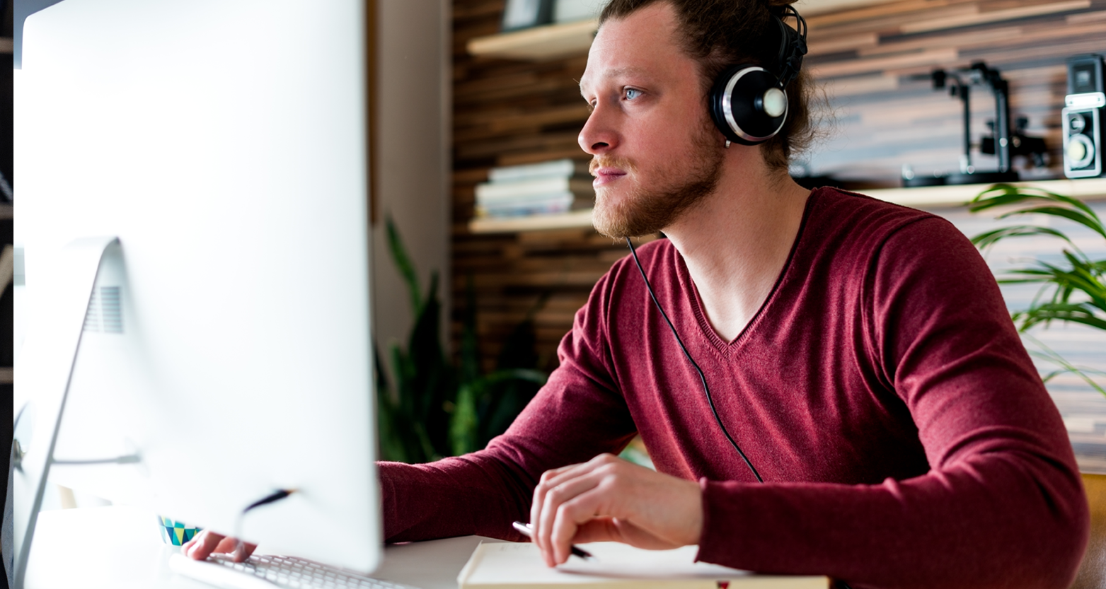 Man at computer wearing headphones