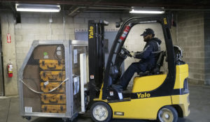 A cage of ventilators is moved by forklift, Tuesday, March 24, 2020 at the New York City Emergency Management Warehouse. On March 27, President Donald Trump used the Defense Production act to push General Motors to build more ventilators. (AP Photo/Mark Lennihan)