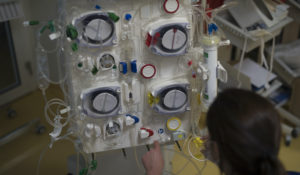 A healthcare worker prepares a dialysis machine to be used for COVID-19 patients in the intensive care unit at the Joseph Imbert Hospital Center in Arles, southern France, Wednesday, April 15, 2020. (AP Photo/Daniel Cole)