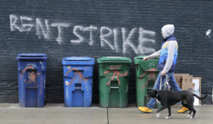 A pedestrian walks past graffiti that reads "Rent Strike" Wednesday, April 1, in Seattle. Some tenants in the U.S. are vowing to go on a rent strike until the new coronavirus pandemic subsides, and some cities have temporarily banned evictions, though those bans are ending soon. (AP Photo/Ted S. Warren)