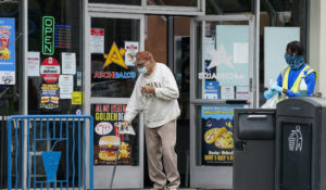 A customer wearing a face mask exits a restaurant in Long Beach, California. (AP Photo/Ashley Landis)