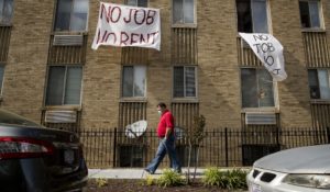 Signs that read "No Job No Rent" hang from the windows of an apartment building during the coronavirus pandemic in Northwest Washington on May 20. As protections end, many renters will face eviction. (AP Photo/Andrew Harnik, File)