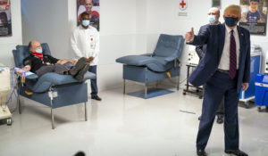 President Donald Trump gives a thumbs up as a patient donates plasma at the American Red Cross national headquarters in Washington, Thursday, July 30, 2020. (Doug Mills/The New York Times via AP, Pool)