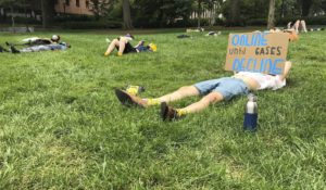 A protester holds a sign opposing in-person classes at a "die-in" at Georgia Tech in Atlanta. More of the state's public universities are opening for the fall term, trying to balance concern about COVID-19 infections against a mandate for on-campus classes citing financial needs and student desires (AP Photo/Jeff Amy)