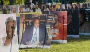 Some of the nearly 900 large poster-sized photos of Detroit victims of COVID-19 are displayed, Monday, Aug. 31, on Belle Isle in Detroit. (AP Photo/Carlos Osorio)