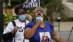 A woman reacts to news in the Breonna Taylor shooting Wednesday in Louisville, Kentucky. A grand jury has indicted one officer on criminal charges six months after Taylor was fatally shot. The jury presented its decision against fired officer Brett Hankison on Wednesday to a judge in Louisville, where the shooting took place. (AP Photo/Darron Cummings)