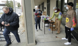 A man arrives to pick up medication for opioid addiction on March 27, 2020, at a clinic in Olympia, Wash., that met patients outdoors and offering longer prescriptions in hopes of reducing the number of visits and the risk of infection due to the outbreak of the new coronavirus. (AP Photo/Ted S. Warren)