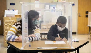 Pre-kindergarten teacher Sarah McCarthy works with a student at Dawes Elementary in Chicago, Monday, Jan. 11, 2021. (Ashlee Rezin Garcia/Chicago Sun-Times via AP, Pool)