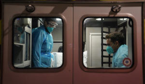 Emergency medical technician Thomas Hoang, left, of Emergency Ambulance Service, and paramedic Trenton Amaro prepare to unload a COVID-19 patient from an ambulance in Placentia, Calif., Friday, Jan. 8, 2021. (AP Photo/Jae C. Hong)