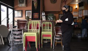 Edith Cordova, co-owner of Cinco de Mayo restaurant, delivers food for customers dining outside, in New York, on Feb. 11, 2021. Restaurants devastated by the coronavirus outbreak are getting a lifeline from the pandemic relief package just signed by President Joe Biden. (AP Photo/Mark Lennihan, File)