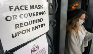 A sign asking customers to wear a face covering is displayed at the entrance to Picos restaurant Wednesday, March 10, 2021, in Houston. Picos, like many restaurants across the state, continue to operate at a reduced capacity and ask customers to wear masks despite Texas Gov. Greg Abbott ending state mandates. (AP Photo/David J. Phillip)