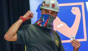 Local 28 Sheet Metal Worker Demetrius Buttelman gestures after being inoculated with the first dose of the Pfizer vaccine during a news conference, Wednesday, April 14, 2021 at the Belmont Park in Elmont, N.Y. (AP Photo/Mary Altaffer, Pool)