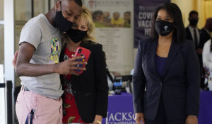 First lady Jill Biden, center, poses for a selfie with a vaccination recipient during a tour of a COVID-19 vaccination site at Jackson State University in Jackson, Miss., Tuesday, June 22, 2021, as part of the administration's nationwide tour to reach Americans who haven't been vaccinated and promote vaccine education. (AP Photo/Rogelio V. Solis)