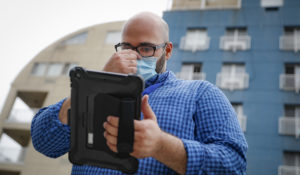 Joseph Ortiz, a contact tracer with New York City's Health + Hospitals, uses his tablet to gather information as he heads to a potential patient's home, in New York on Aug. 6. 2020. (AP Photo/John Minchillo, File)