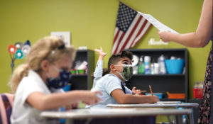 A student listens to the teacher's instructions at iPrep Academy on the first day of school, Monday, Aug. 23, 2021, in Miami. Schools in Miami-Dade County opened Monday with a strict mask mandate to guard against coronavirus infections. (AP Photo/Lynne Sladky)