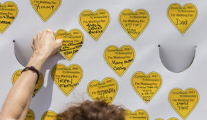 COVID-19 survivors gather at City Hall Park and place stickers representing lost relatives on a wall after marching across the Brooklyn Bridge on Saturday, Aug. 7, 2021 in New York. (AP Photo/Stefan Jeremiah)