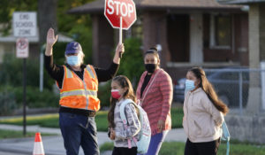 Anna Alfaro arrives at Whittier Elementary School with her daughters Guadalupe, right, and Allison, center, on Tuesday, Aug. 24, 2021, in Salt Lake City. (AP Photo/Rick Bowmer)