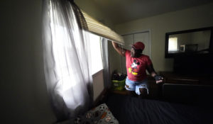 Natasha Blunt looks at the mold from Hurricane Ida in the window of her grandson's room, in Chalmette, La., Monday, Sept. 6, 2021. Before the hurricane hit, the New Orleans native had hardly recovered from facing eviction and loss of her catering job during the pandemic. The storm, which left her in the dark and without power for several days, has taken Blunt to the brink. Unable to work as her health deteriorates from a pair of strokes, Blunt is still facing eviction while she cares for her 5-year-old grandson. (AP Photo/Gerald Herbert)