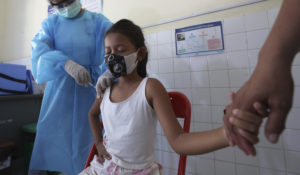 A young girl holds her mother’s hand as she receives a COVID-19 vaccine at a Samrong Krom health center outside Phnom Penh, Cambodia, Friday, Sept. 17, 2021. (AP Photo/Heng Sinith)