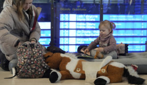 A woman plays with her child, who sits on an air mattress, at the train station in Warsaw, Poland, Sunday, March 13, 2022. More than 1.5 million refugees have arrived in Poland since the start of Russia's invasion of Ukraine on Feb. 24, out of a total of around 2.7 million people that the United Nations say have fled so far. (AP Photo/Czarek Sokolowski)