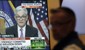 As the Federal Reserve announces a rate change, traders work and watch at the New York Stock Exchange in New York, Wednesday, July 27, 2022. (AP Photo/Seth Wenig)