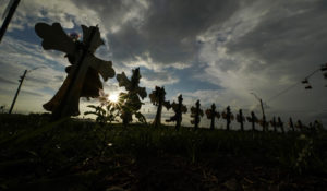 Vehicles pass crosses placed to honor the victims of the May 23 shootings at Robb Elementary School in Uvalde, Texas. (AP Photo/Eric Gay)