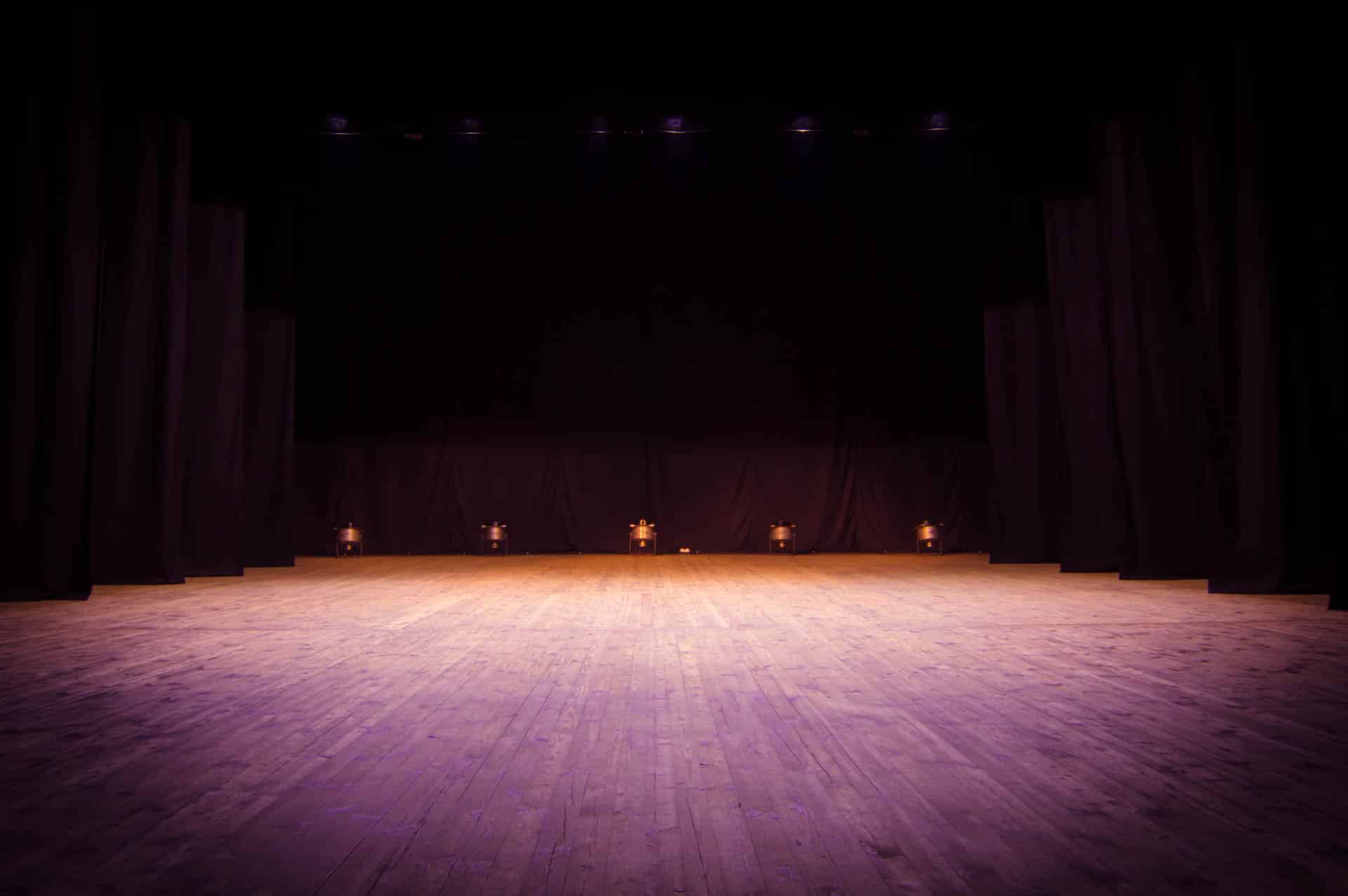 An empty stage of the theater, lit by spotlights before the performance