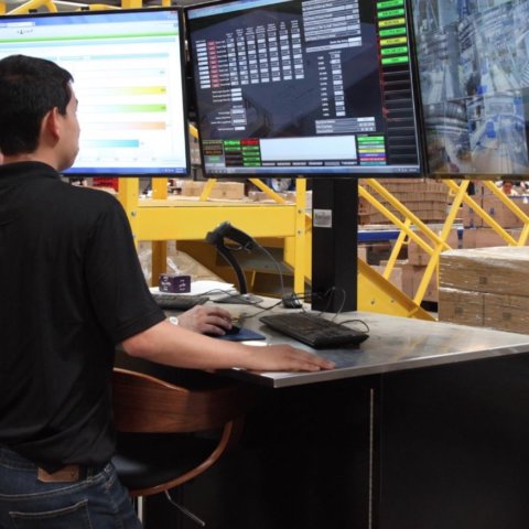 Two associates use an automated industrial control system for their warehouse operation