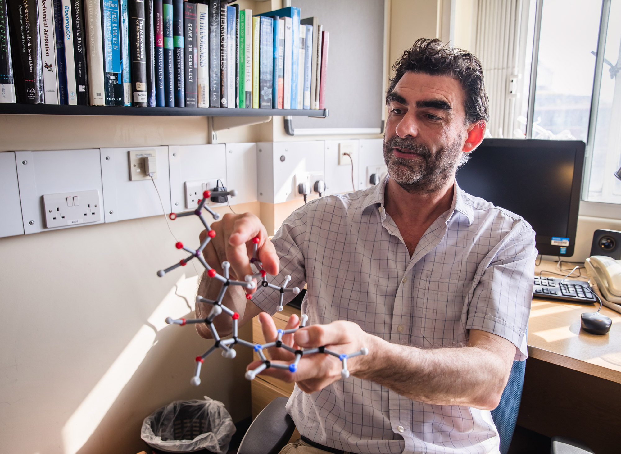 Nick Lane of University College London holds a model of an ADP molecule in his office.