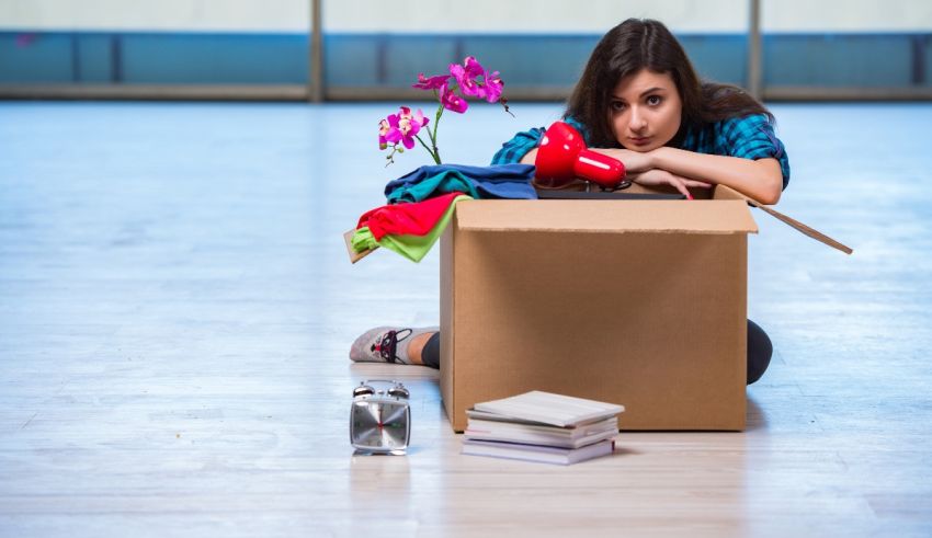 A woman sitting in a cardboard box with a flower in it.