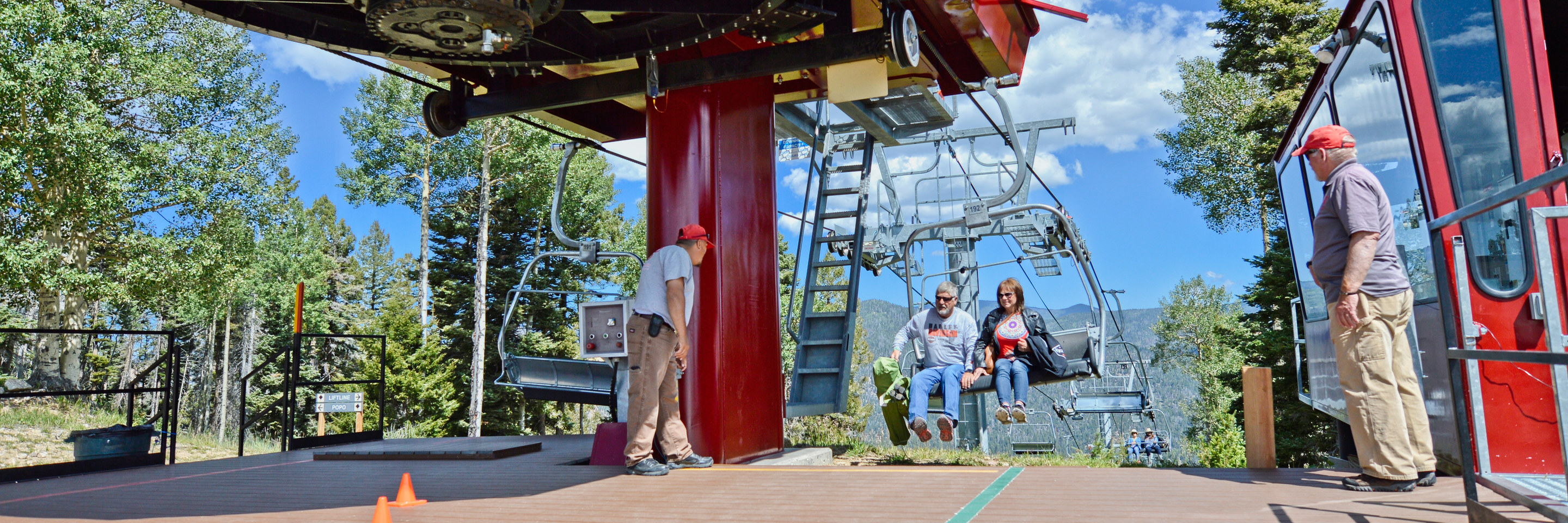 Couple unloading scenic summer chairlift ride at the top