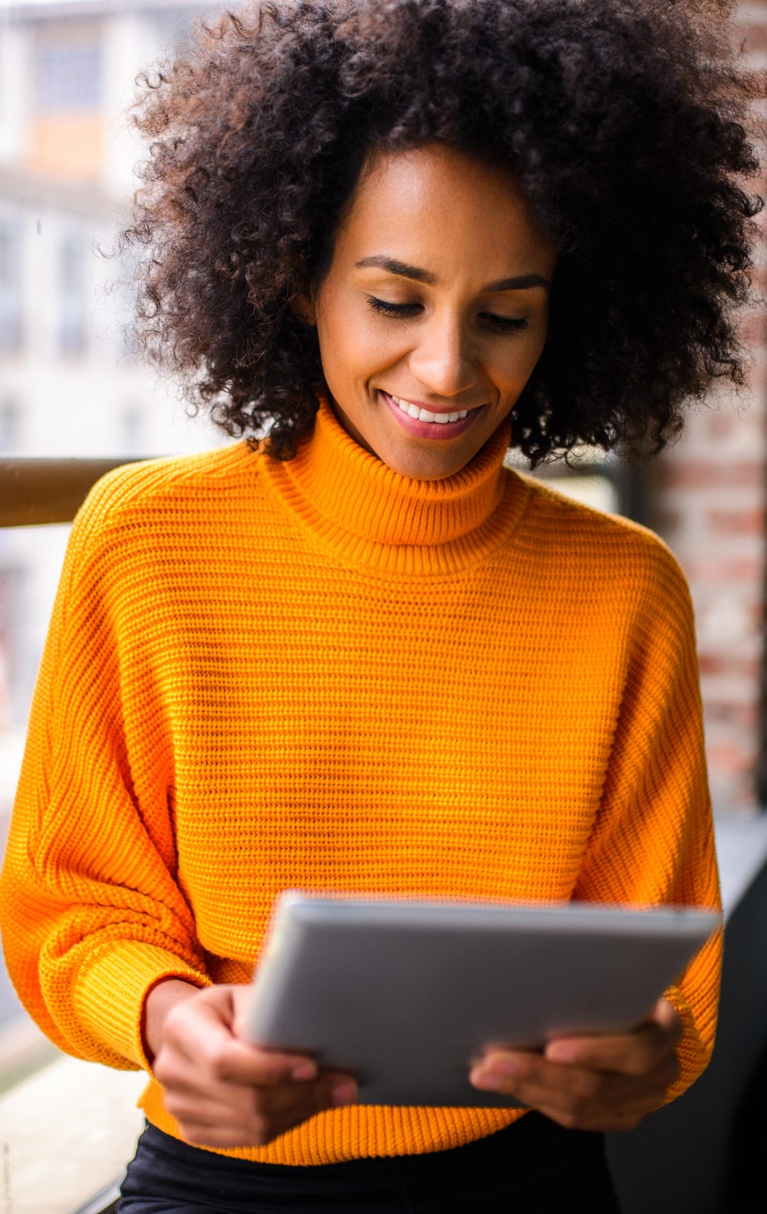 Smiling woman using digital tablet.