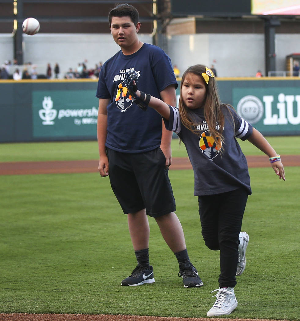 Hailey Dawson, 9, throws the first pitch alongside her brother, Zach, 14, before the start of t ...