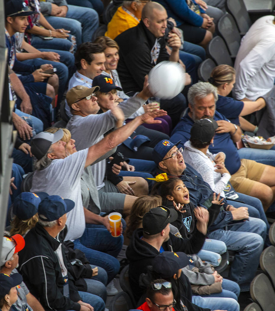 Fans bat around a blow-up baseball in the stands the Las Vegas Aviators home opener on Tuesday, ...