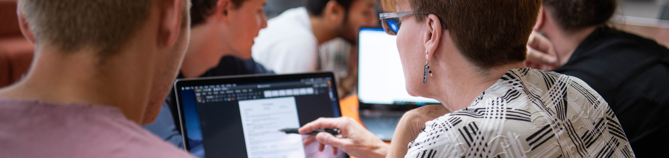 Two people looking at a résumé on a laptop.