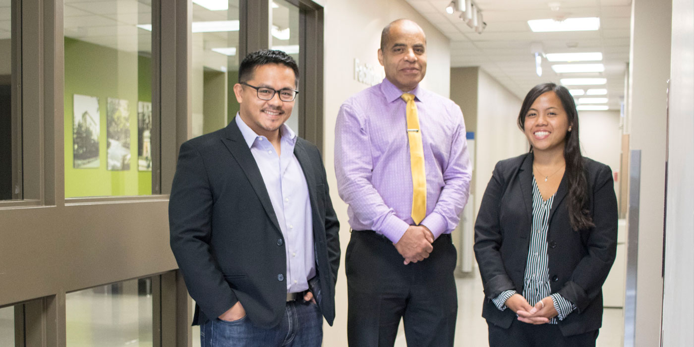 Three staff members smiling for a group photo.