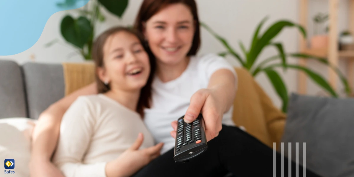 Mother and daughter sitting on a couch with the mother holding out a TV remote control wanting to set up parental controls on Roku