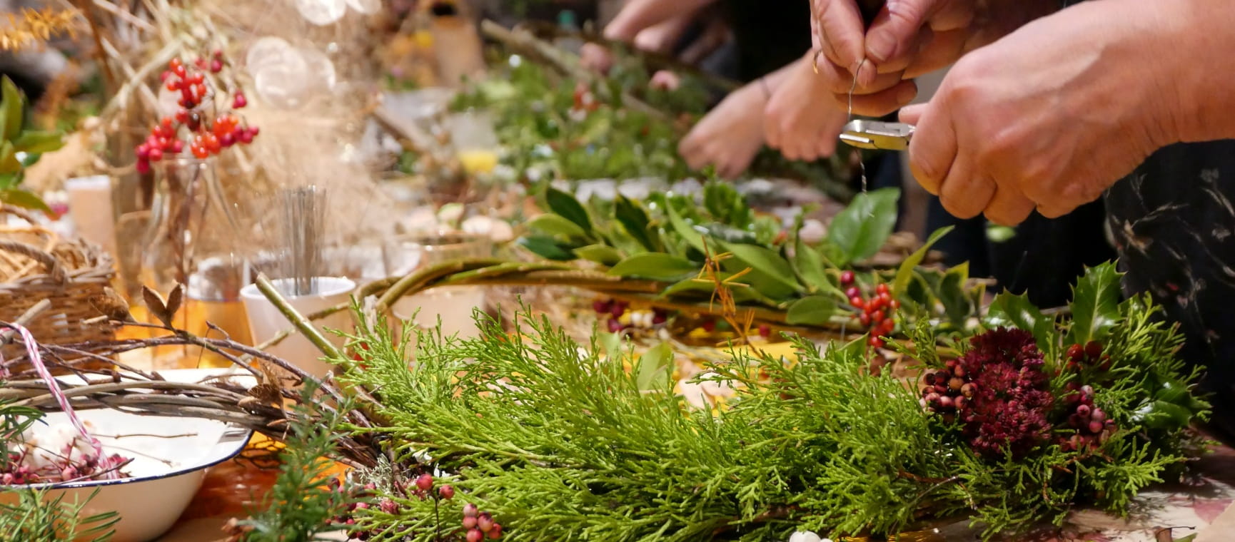 Handmaking a Christmas wreath using foliage and berries