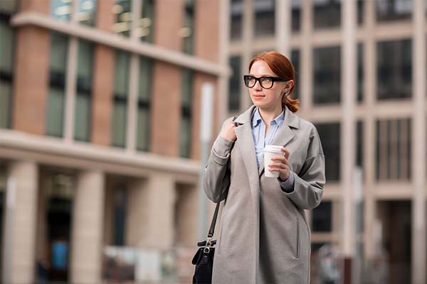 A woman holding a cup of coffee outdoors