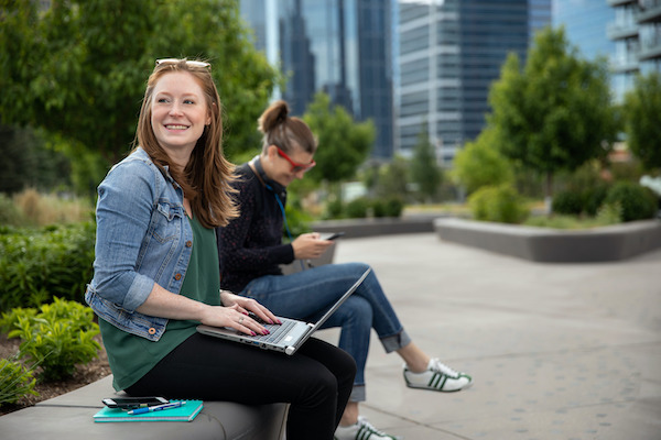 Two students sitting outside on a bench