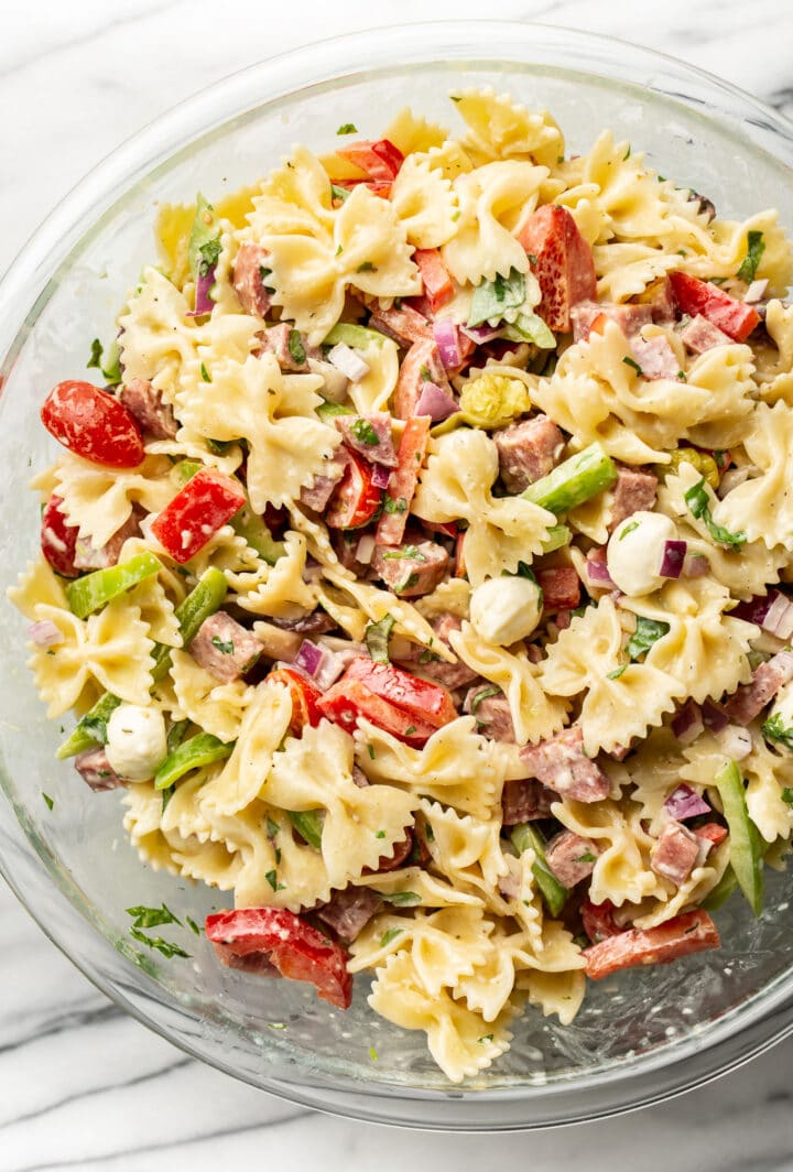 a glass bowl with italian pasta salad