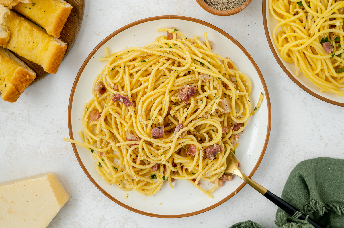 overhead shot of fork in plate of carbonara