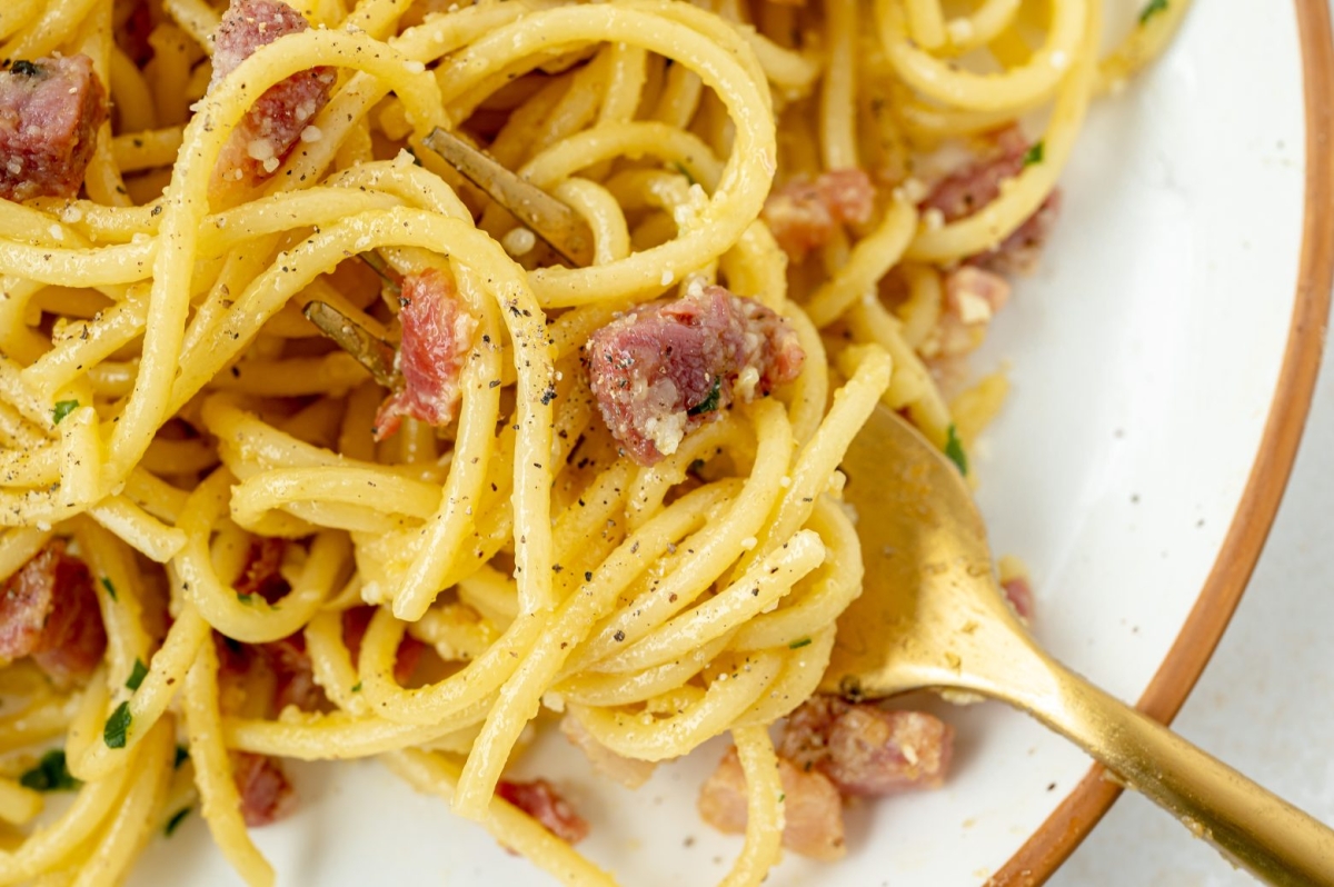 close up overhead shot of bite of carbonara on fork