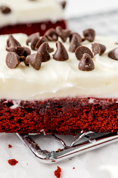 angle view of red velvet brownie with thick cream cheese frosting and chocolate chips